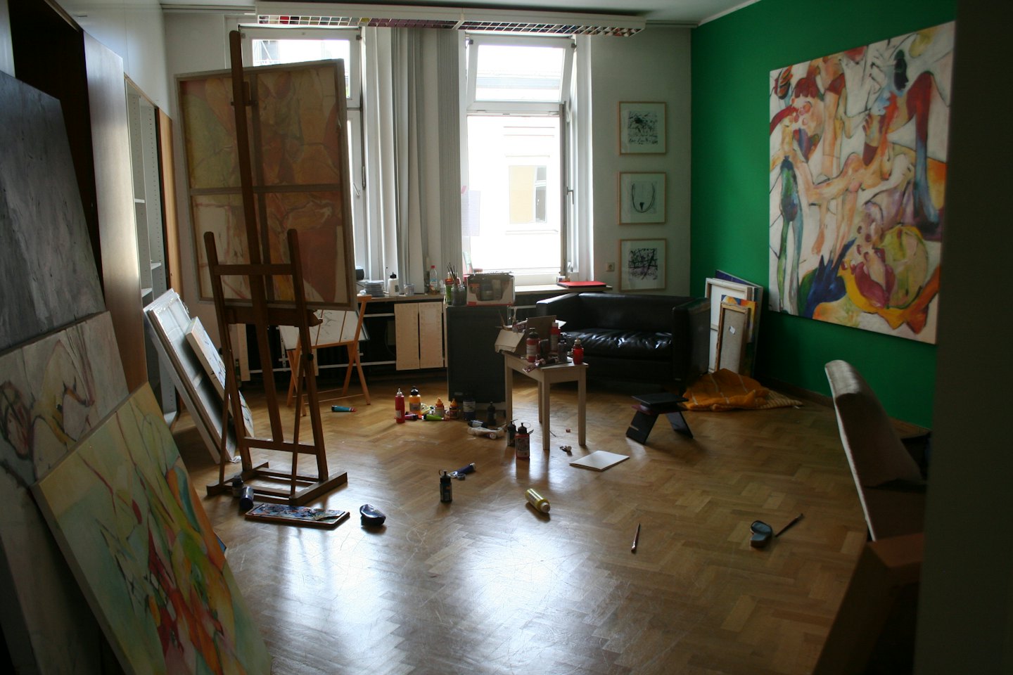 Artist's studio with canvases, easels, and supplies.