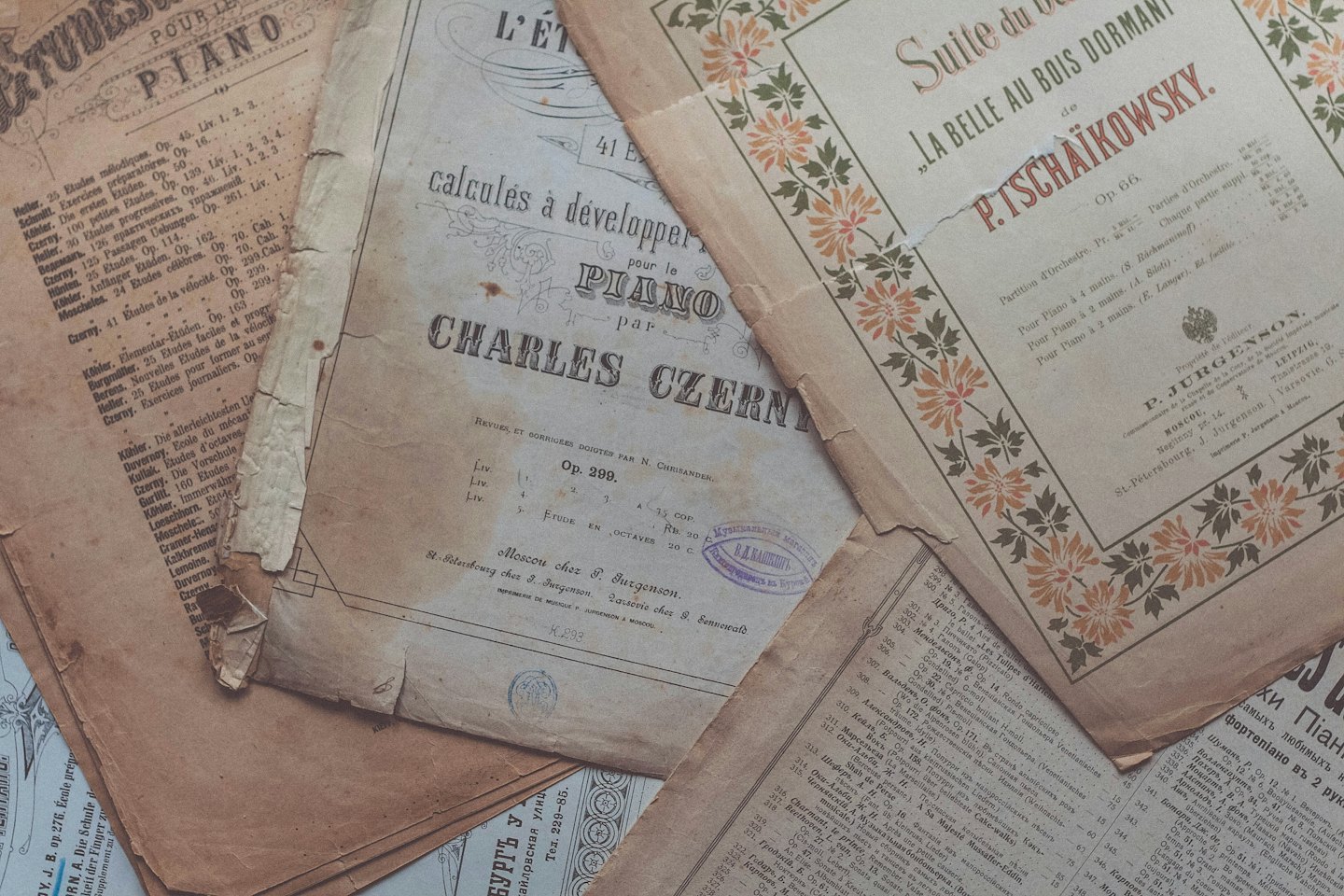 Antique sheet music scattered across a flat surface.